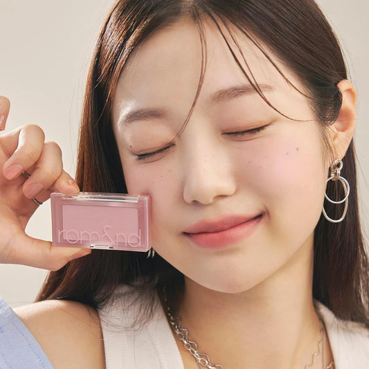 Model with eyes closed holding the rom&nd Better Than Cheek N02 Vine Nude compact