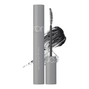 Open rom&nd Han All Fix Mascara L01 Long Black 7g tube and wand beside a black brush stroke on a white background.