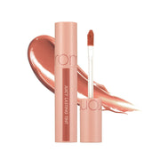rom&nd Juicy Lasting Tint 22 Pomelo Skin open tube over a peach-coral swatch