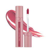 Open rom&nd Juicy Lasting Tint 25 Bare Grape 5.5g tube and wand beside a pale mauve swatch on a white background.