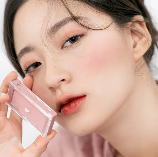 Model holding the rom&nd Better Than Cheek C02 Blueberry Chip compact beside a softly flushed cheek