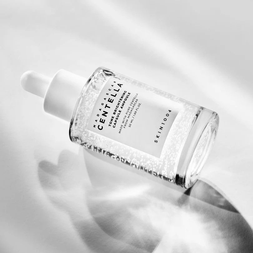 SKIN1004 Tone Brightening Capsule Ampoule 50ml bottle lying in bright light with a soft shadow.