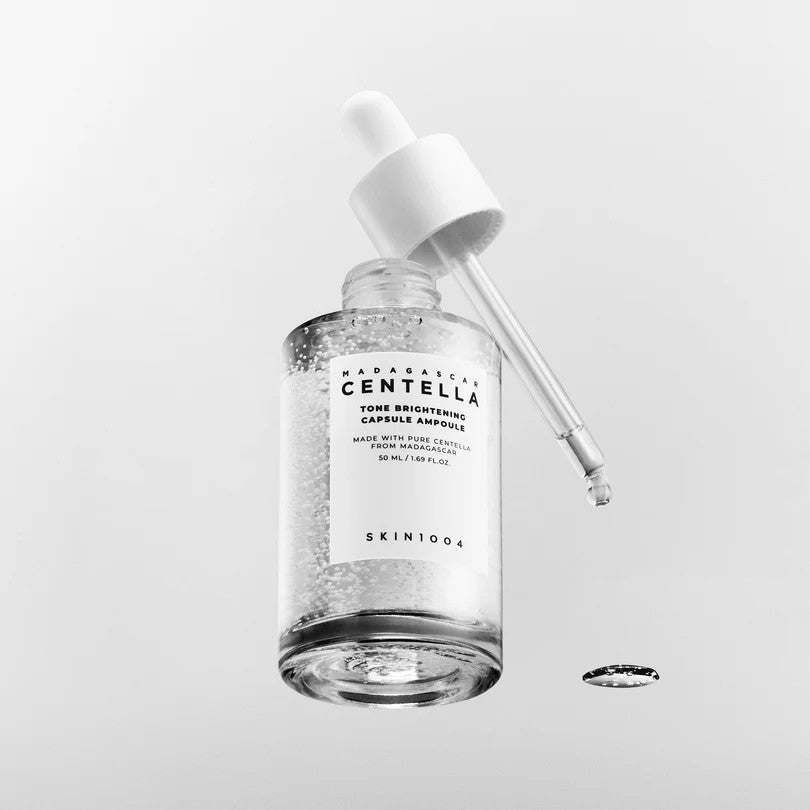 Open SKIN1004 Tone Brightening Capsule Ampoule 50ml bottle with its white dropper raised above a clear droplet.